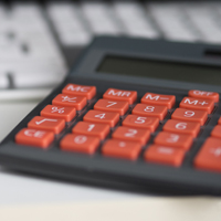 close up of a calculator on a desk in front of a keyboard